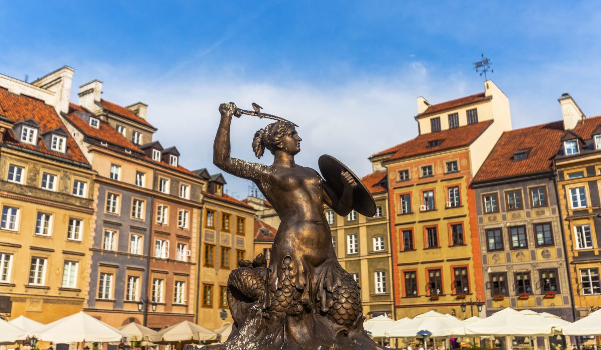 Warrior mermaid statue as a symbol of Warsaw in a day at springtime. Patterns and colors of the old buildings seem very nice at sunlight. Sky is cloudy and clear in Warsaw, Poland.