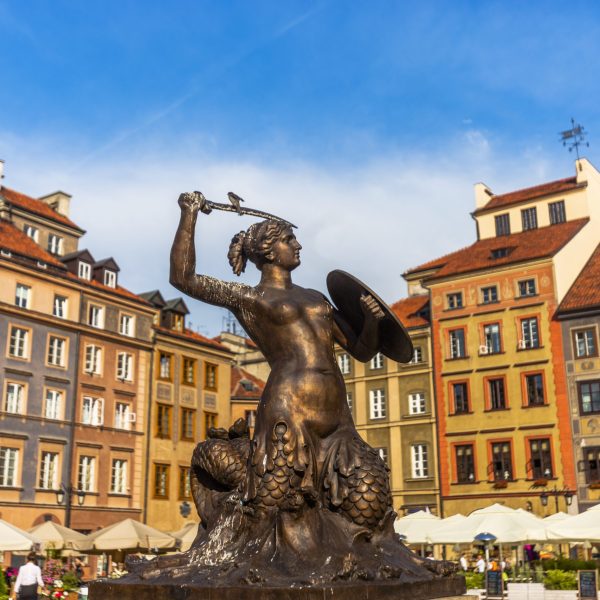 Warrior mermaid statue as a symbol of Warsaw in a day at springtime. Patterns and colors of the old buildings seem very nice at sunlight. Sky is cloudy and clear in Warsaw, Poland.